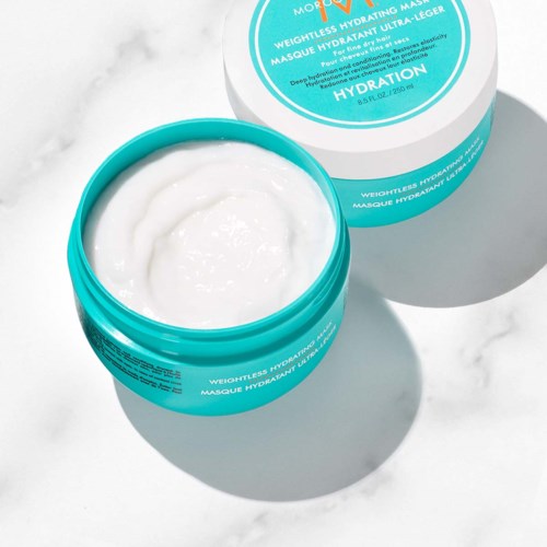 A blue and white jar of hydrating face mask, with packaging in the background on a light surface.