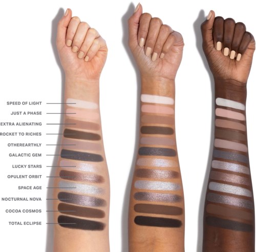 Tre armar med olika hudtoner visar swatches av olika ögonskuggor, från ljusa till mörka, i en vertikal linje.