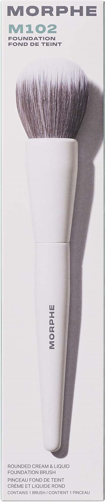A makeup brush with a white handle and fluffy bristles, used for applying foundation and cream products.