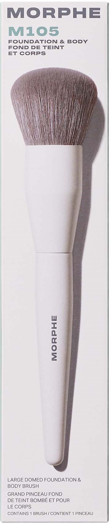 A white makeup brush with soft bristles stands upright on a box marked Morphe M105. It is for foundation and body use.