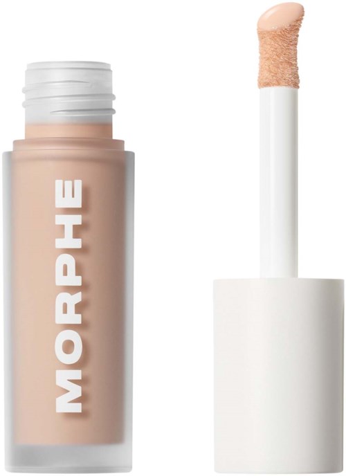 En tub med flytande concealer med vit lock och en applikatorborste bredvid.