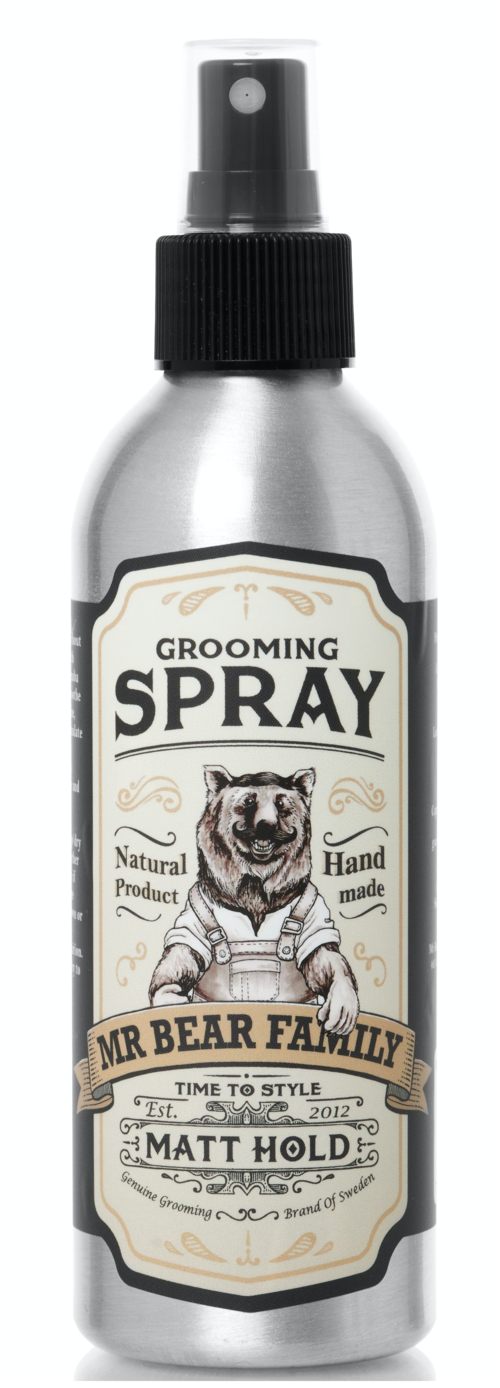 A silver spray bottle with a black cap and label, featuring a bear illustration and text about grooming for dogs.
