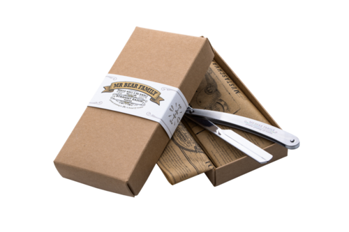 A brown box with a white label, opened to reveal tools and wood inside.
