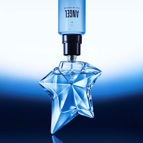 En parfymeflaske er dekorert med et stjerneformet design, med en blå spray-hette og merkevarenavn AUBE.