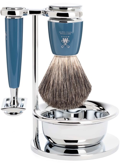 A shaving kit with a stand, including a blue razor, an electric shaver, a shaving brush, and a metal bowl.