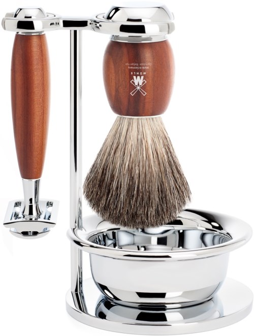 A shaving set with a brush, handle, and a stand in metal and wood. The brush has soft bristles. There is a logo on the handle.
