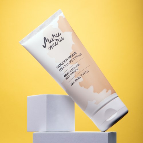 The tube of sunscreen is tilted and balanced on two white blocks with a yellow background.
