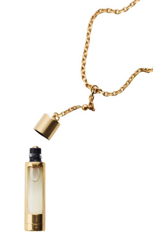 Een gouden ketting met een kleine ronde hanger en een doorzichtige parfumfles met zwarte dop.
