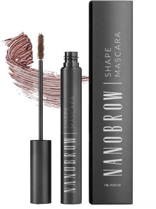 Een mascara-tube staat naast de doos en een mascara-borstel toont bruin mascara. De tube heeft witte tekst op een zwarte achtergrond.
