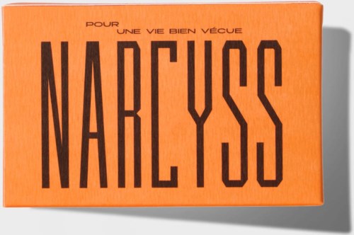 Oranger Karton mit schwarzem Text, sagt "Pour une vie bien vécue Narcyss."