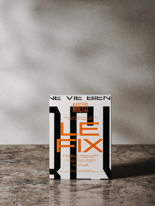 Buch mit dem Titel "Le Fix" steht auf einem strukturierten Tisch vor einer schlichten Wand.
