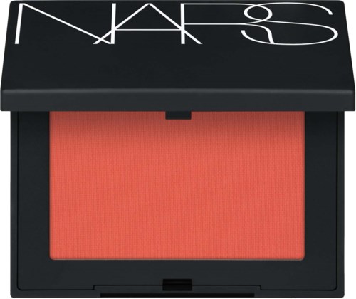 A NARS blush compact with a bold peachy shade inside. The black case has a white logo on the lid.