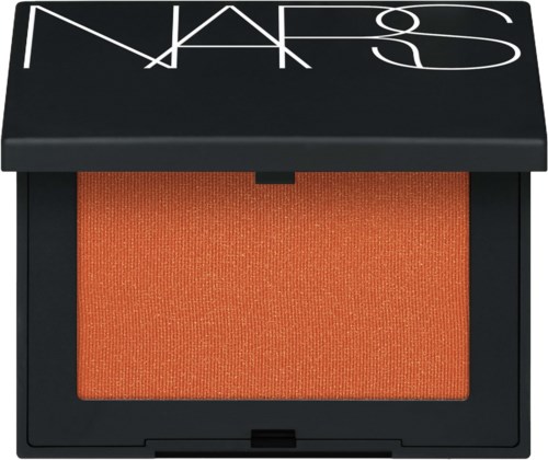 A NARS makeup compact with orange blush inside and a black lid with white branding.