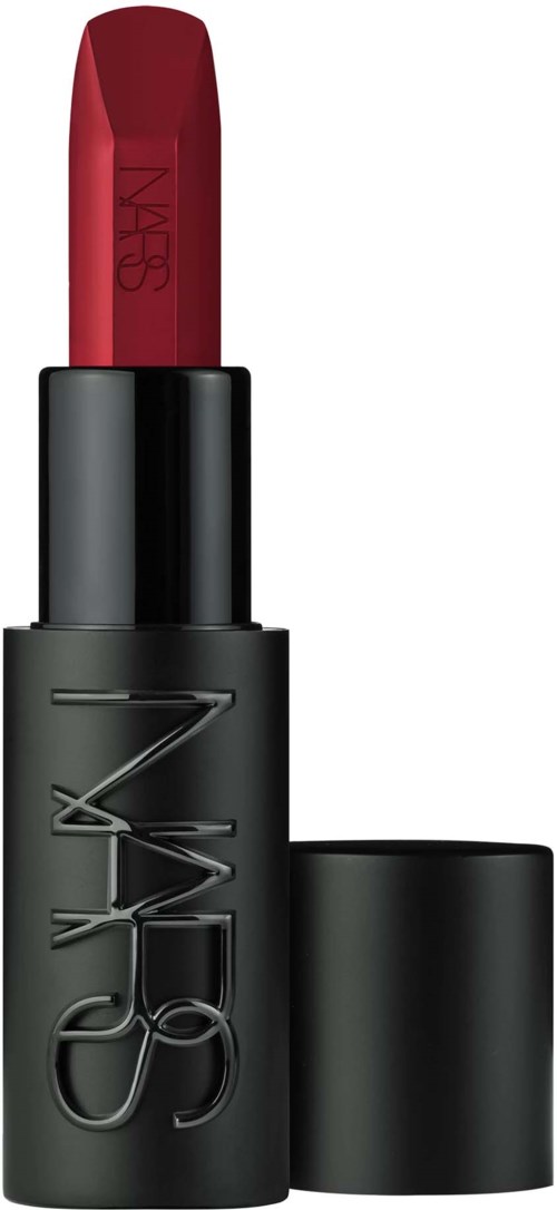 A black lip balm tube with NOMADA logo, open to show red lipstick inside.