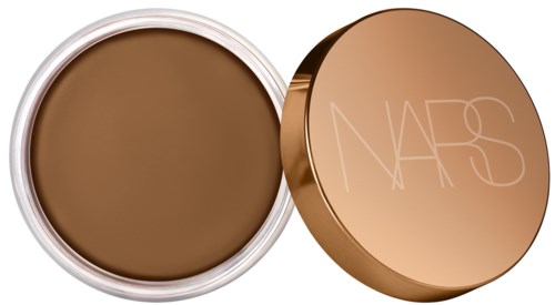 Pyöreä rasia, jossa on ruskea meikki tai kasvomatto, ja messinkimusta kansi, jossa on NARS-logo.