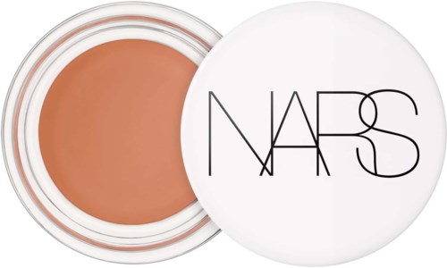 Pyöreä NARS-poskipuna-astia, jossa valkoinen kansi ja persikanvärinen meikki sisällä.