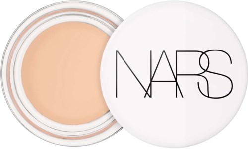 A small jar of beige makeup with NARS logo on the white lid.