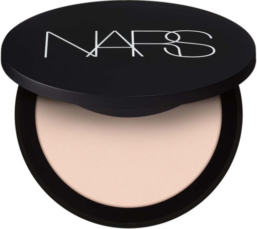 Pyöreä musta säilytinhylly, jossa on NARS-logo ja sisältää vaaleaa irtopuuteria.
