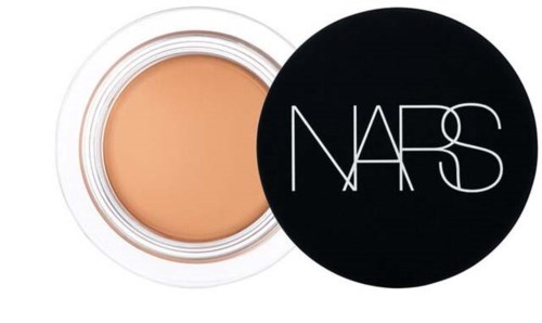 A round container of beige cream with a black lid reading 'NARS'.