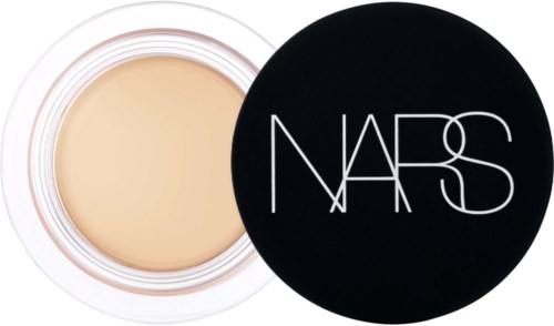 A compact makeup product with a beige cream inside and a black lid labeled NARS.
