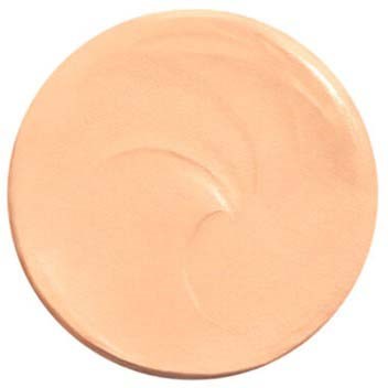 A round, light beige compact with some cream or foundation inside and a swirl pattern.