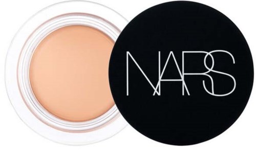 A beige makeup product in a round container with a black lid featuring the NARS logo.