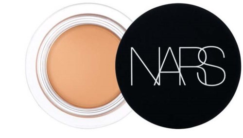 A round container with beige makeup product inside, and a black lid with white NARS logo.