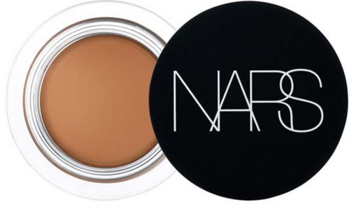 A compact with beige cream and a black lid with white 'NARS' logo.