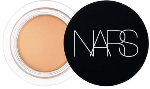 A NARS foundation or concealer in a round container with a black lid showing the brand name.