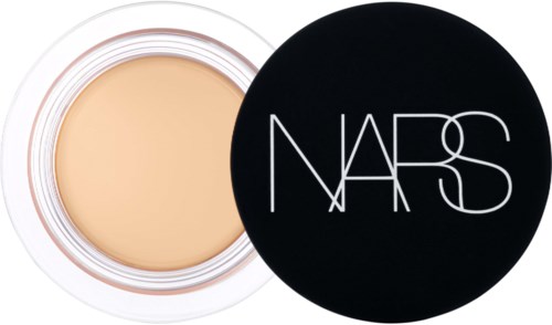 A compact makeup product with a beige cream inside and a black lid with white NARS logo.