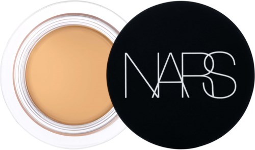 A round container with beige cream inside and a black lid with 'NARS' written on it.