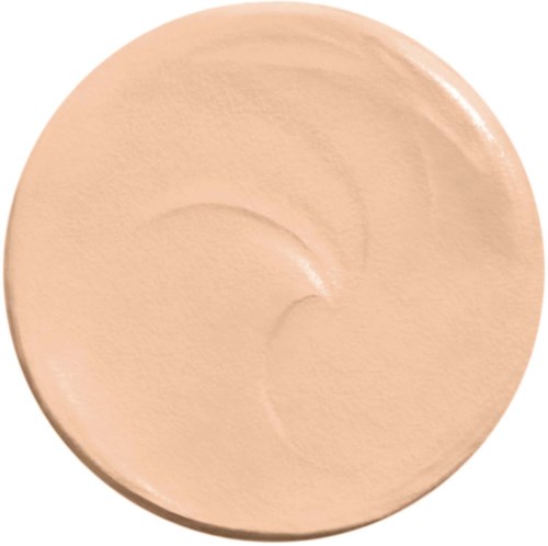 A beige-colored makeup foundation or cream in a round container. It has a smooth, slightly shiny surface.