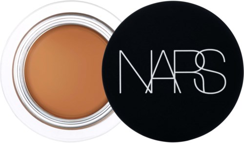 A round container with beige foundation and a black lid with 'NARS' written on it.