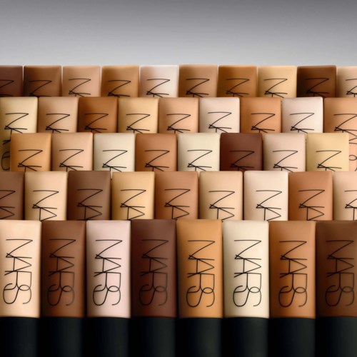 Rows of NARS foundation bottles in different skin shades arranged neatly. The bottles are rectangular with black caps.