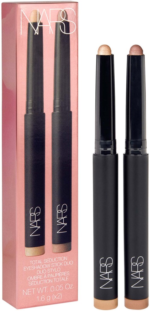 Två NARSögonskuggsfärger med svarta kroppar och beige lock framför deras rosa förpackningslåda.