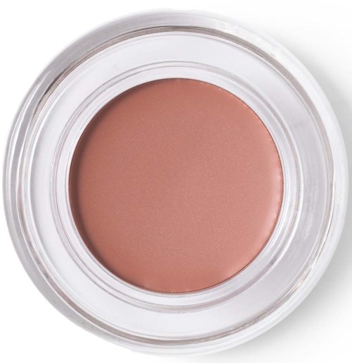 Een ronde container met perzikkleurige crème of blush. De container is helder en eenvoudig.