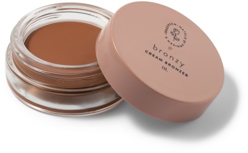 Een kleine ronde pot met bronscrème en een roze deksel, gelabeld "DROZY CREA BRONZER OL."
