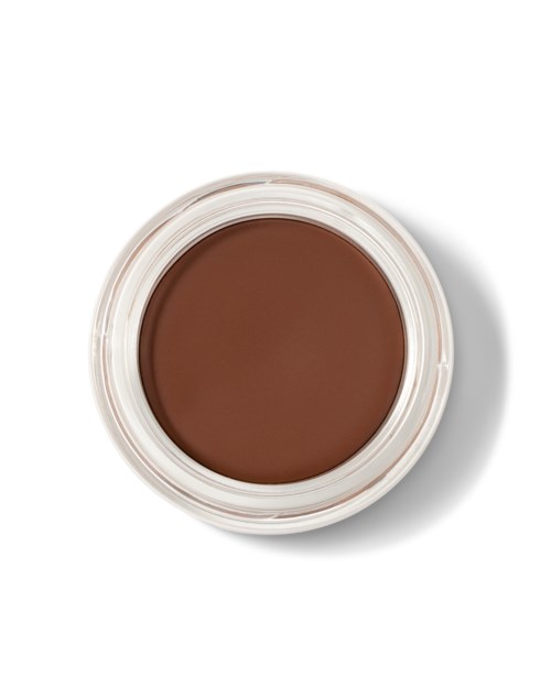 Bruine make-upproduct in een kleine ronde container, vanaf boven gezien. Geen etiketten zichtbaar.