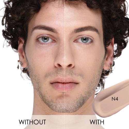 Ein Mann zeigt den Unterschied mit und ohne Make-up oder Hautfarbe, mit einem geteilten Gesicht und einem Make-up-Probe.