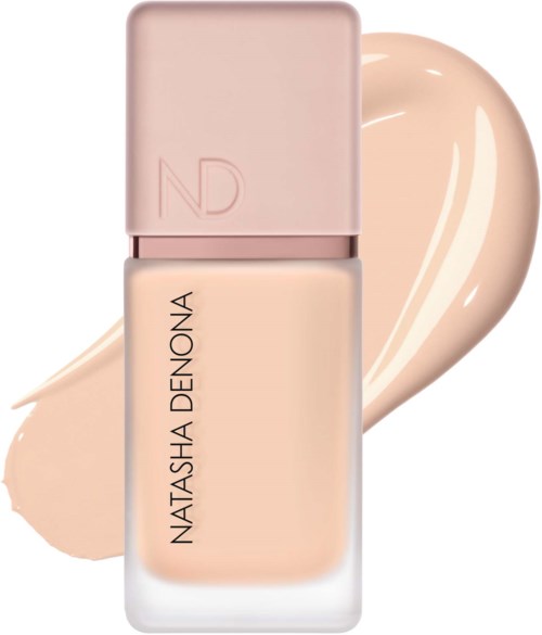Eine Flasche Foundation von Natasha Denona mit rosa Deckel und beiger Flüssigkeit.