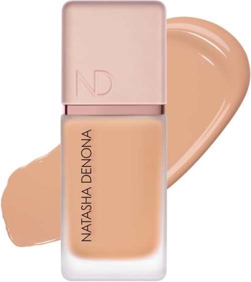 NATASHA DENONA Foundation-Flasche mit beigeem Farbklecks im Hintergrund. Die Flasche hat einen hellrosa Deckel und schlichte Schrift.
