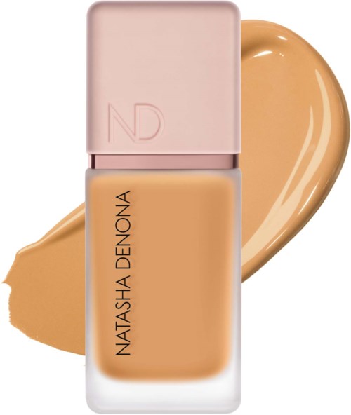 Eine beigen Foundation-Flasche mit rosa Deckel und Natasha Denona-Label, mit Foundationswunsch dahinter.
