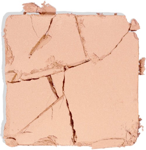Zerbroenes beiges Make-up-Puder mit großen Rissen und fehlenden Teilen.