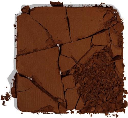 Zerbröseltes braunes Pulver und zerbrochene Stücke eines Blocks auf weißem Hintergrund.