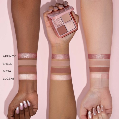 Verschiedene Schattierungen von Makeup sind auf drei Armen, halten eine passende Palette, vor rosa Hintergrund.