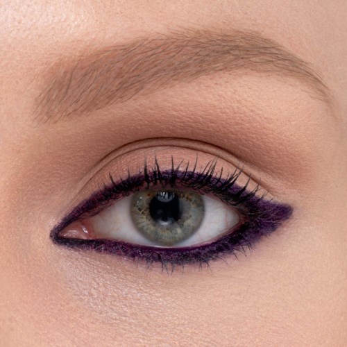 Nahaufnahme eines Frauenauges mit Make-up, einschließlich lila Eyeliner und langen Wimpern.