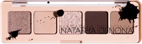 Vier beige und braune Lidschatten in einer Palette mit schwarzen Tintenflecken und einem Namen darauf.