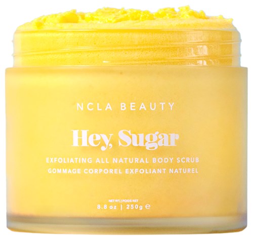 Gelbes Körperpeeling mit weißen Text, offener Behälter zeigt Peelingtextur, Marke ist NCLA Beauty und Hey Sugar.