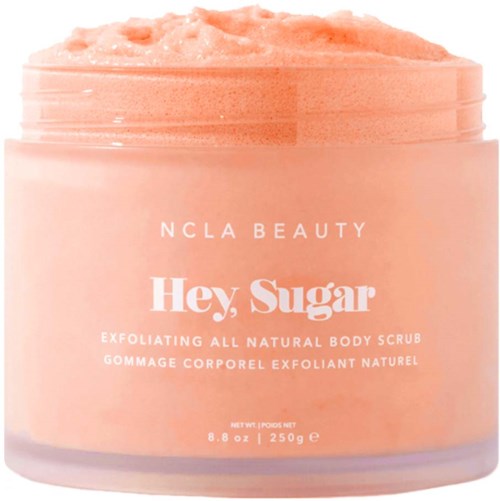 Ein rosa Behälter mit natürlichem Körperpeeling 'Hey, Sugar' von NCLA Beauty mit sichtbarer exfolierender Konsistenz.
