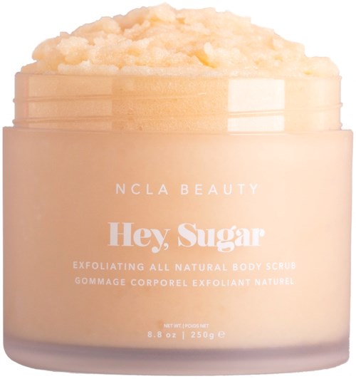A jar of natural body scrub with a peach-colored cream on top, labeled 'Hey, Sugar' by NCLA Beauty.